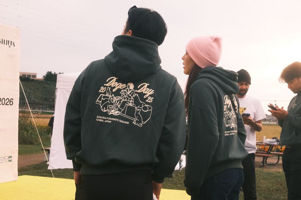 Two visitors in Doge Day hoodies, seen from behind